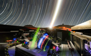 Diese langzeitbelichtete Nacht-Aufnahme zeigt die Teleskope des NGTS während der Testphase. Der hell leuchtende Mond erscheint in der Mitte des Bildes. Außerdem sind am Horizont die Kuppeln der Teleskope von VISTA (rechts) und VLT (links) zu erkennen.
(Bild: ESO, G. Lambert)