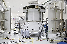 Die drei gewölbten Verkleidungspaneele werden um das Servicemodul herum angebracht.
(Bild: NASA)