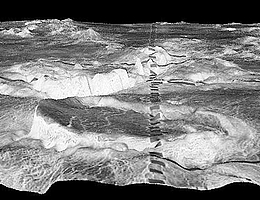 Der kreisrunde Berg im Vordergrund ist eine 500 Kilometer grosse Corona in der Galindo-​Region der Venus. Die dunklen Rechtecke sind ein Artefakt.
(Bild: NASA/JPL/USGS)