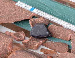 Vom DLR beauftragte Mitglieder des Arbeitskreis Meteore (AKM) dokumentierten kurz nach dem Meteoritenfall ein 233,4 g schweres Steinmeteoriten Fundstück und die beschädigten Dachpfannen. (Bild: Carsten Jonas, AKM)