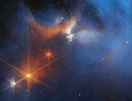 Dieses Bild des James Webb-Weltraumteleskops der NASA/ESA/CSA zeigt die zentrale Region der dunklen Molekülwolke Chamäleon I, die sich in 630 Lichtjahren Entfernung befindet. Das kalte, dünne Wolkenmaterial (blau, Mitte) wird im Infraroten durch den jungen Proto-Stern Ced 110 IRS 4 (orange, oben links) beleuchtet, der auch einen Sternwind aussendet. Das Licht zahlreicher Hintergrundsterne, die als orangefarbene Punkte hinter der Wolke zu sehen sind, kann genutzt werden, um Eis in der Wolke aufzuspüren, welches das hindurchgehende Sternenlicht absorbiert. (Bild: NASA, ESA, CSA, and M. Zamani (ESA/Webb))