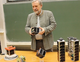 Klaus Schilling mit einigen der Kleinsatelliten, die in seinem Team zusammen mit Studierenden entwickelt wurden. (Bild: Dieter Ziegler / Universität Würzburg)