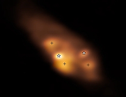 Ein detaillierter Blick auf die jungen Doppelsterne (markiert durch Sternsymbole) im System IRAS 16293-2422. In diesem Radiobild, das mit dem Atacama Large Millimeter/Submillimeter Array in Chile aufgenommen wurde, zeigt die Farbe die Temperaturverteilung der Protosterne und ihrer Umgebung an, wobei weiß auf eine hohe Temperatur hinweist. Die drei Hot Spots (durch Kreuze markiert) werden höchstwahrscheinlich durch Schocks erhitzt, nicht durch die Protosterne selbst. (Bild: ALMA (ESO/NAOJ/NRAO)/Maureira et al.))