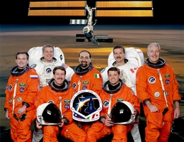 STS-100-Crew mit Missionslogo und ISS-Modell. (Bild: NASA)