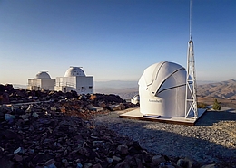 Das neue Test-Bed Telescope 2, ein Teleskop der Europäischen Weltraumorganisation, befindet sich auf diesem Foto in der glänzenden weißen Kuppel am La Silla Observatorium der ESO in Chile. Das Teleskop hat jetzt seinen Betrieb aufgenommen und wird seinen Zwilling auf der nördlichen Hemisphäre dabei unterstützen, uns vor potenziell gefährlichen erdnahen Objekten zu schützen. Die Kuppeln des 0,5-m-Teleskops der ESO und des dänischen 0,5-m-Teleskops sind im Hintergrund dieses Bildes zu sehen. (Bild: I. Saviane/ESO)