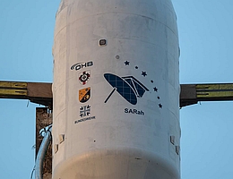 Eine bewährte Kooperation: Beschaffungsamt und Kommando Cyber- und Informationsraum. Die Wappen sind neben dem Hersteller-Logo und dem Bundeswehr-Logo groß aufgedruckt. (Bild der Nutzlastverkleidung: SpaceX via Bundeswehr. Bildunterschrift: Bundeswehr)