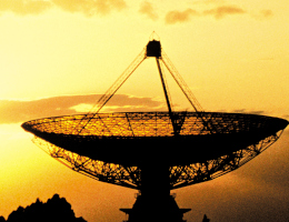 Eine riesige runde Parabolantenne im Gegenlicht