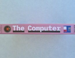 Buchrücken in rosa mit der Aufschrift "The Computer". Oben erkennt man das "Kameraauge" von HAL 9000, dem Computer aus "2001 - Odysee im Weltraum", unten sind eine 3,5"-Diskette und das Wort "TASCHEN" aufgedruckt. Bild: Stefan Goth