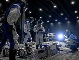 Team BREMEN während der ESA Space Resources Challenge 2025 in der LUNA-Halle beim DLR in Köln Das System, bestehend aus dem mobilen Rover „Coyote III“ (links) und einer stationären Aufbereitungseinheit (rechts), kann Mondstaub sammeln und sortieren. Aus Mondstaub sollen zukünftig Ressourcen wie Sauerstoff und Baumaterialien direkt vor Ort auf dem Mond gewonnen werden können. Credit: © DLR. Alle Rechte vorbehalten