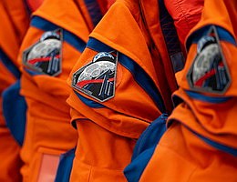 Das Artemis-II-Missionsabzeichen ist auf der rechten Schulter der Orion-Crew-Survival-System-Anzüge zu sehen, die die NASA-Astronauten Reid Wiseman, Victor Glover und Christina Koch sowie der CSA-Astronaut (Canadian Space Agency) Jeremy Hansen beim Artemis-II-Testflug tragen werden. Das Foto wurde am 17. Januar 2026 im Ankleideraum des Neil A. Armstrong Operations and Checkout Building im Kennedy Space Center der NASA in Florida aufgenommen. Bildnachweis: NASA/Joel Kowsky